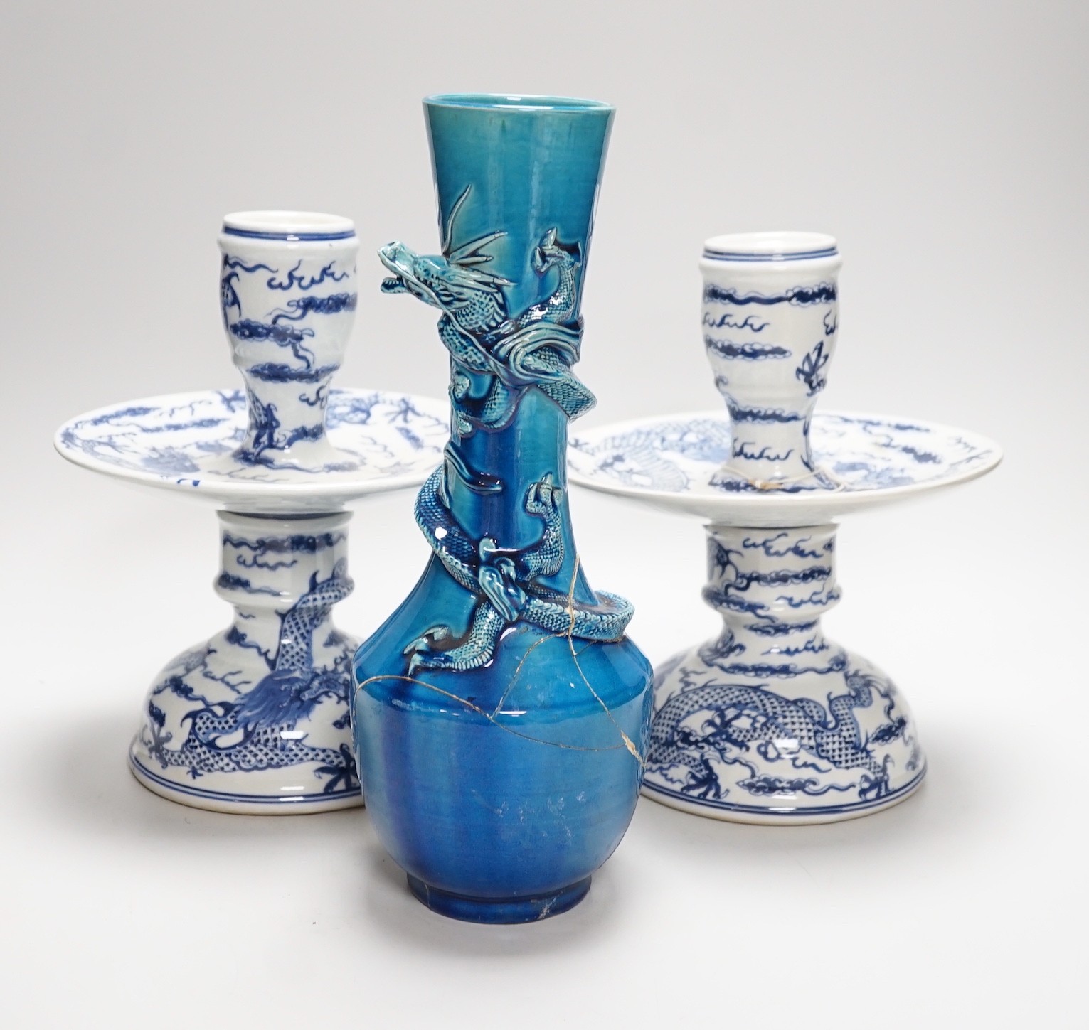 Two Chinese blue and white candlesticks and a turquoise glaze dragon vase, 30cms high